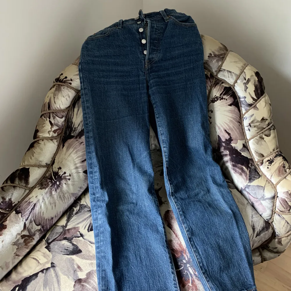 Säljer mina fina mörkblåa Levis i strl w25 l27. Jeansen är högmidjade och sitter så snyggt på. På mig som är 160 cm lång slutar jeansen vid fotknölen ungefär. De är använda men i bra skick. Nypris är ca 1200 kr. Säljer för 400 kr + frakt.. Jeans & Byxor.