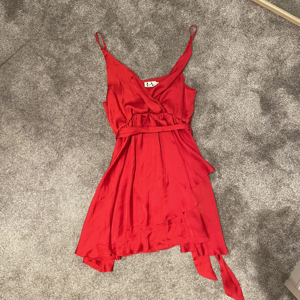 Röd klänning som knappt är använd. Passar perfekt till tex julafton eller någon fest. V- ringad och har ett band man kan ta ut men också knyta (se 3 bild). Köpt från NA-KD x Linn Ahlborg i storlek 38.. Klänningar.