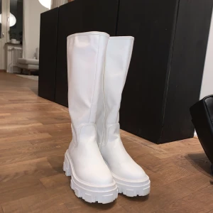 Stövlar  - Säljer dessa snygga vita stövlar från Nelly. Passar perfekt ill både höst och vinter. Använt ett fåtal gånger. Är i storlek 36