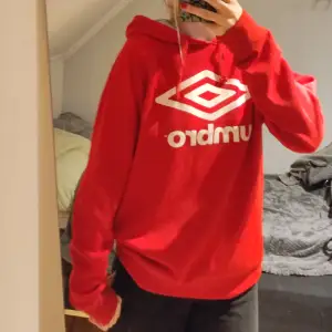 En röd umbro hoodie med stort tryck på bröstet. Jätteskön om jag får söka det själv😄