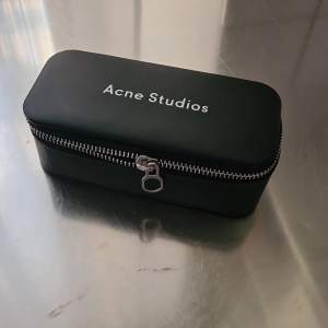 Acne Studios eyewear case(can also be used as a pencil case) in black with white embossed logo on top. Typical Acne Studios pink shade inside. 15cm long, 7cm wide and 5.50cm height. New condition. Selling due to not using sunglasses etc. 