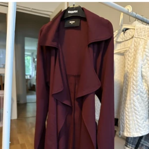 Vinröd kappa - Vinröd tunn kappa. Använd endast en gång.