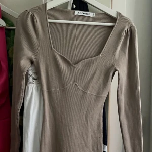Adoore klänning - Roma dress storlek 38 - Nyskick, endast använd/prövad en gång. Storlek 38, men fungerar till 36 och 40 då den är väldigt stretching. Säljes pga inte min stil längre. Mörkbeige färg!