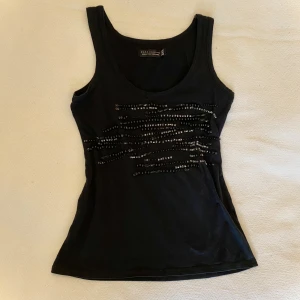 Svart linne  - Ett coolt, svart linne från Zara. Det är i storlek M men funkar nog för de flesta storlekar beroende på hur tight man vill ha det. Detaljerna på framsidan består av jättefina pärlor, men tyvärr har några pärlor ramlat av:( Dock inget man tänker på! 