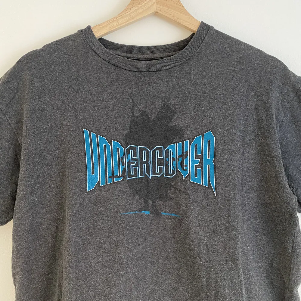 En grå tröja från Undercover från spring summer 2000 med ett tryck. Undercover text + samurai i bakgrunden😎😎Har en lite detalj vid vänster ärm också.  Storlek M, sitter TTS.  Clean tröja. T-shirts.