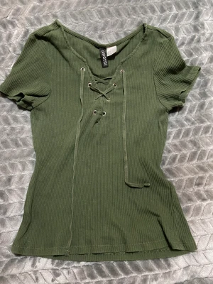 Topp med snörning - Millitärgrön topp från Gina. Strl S.