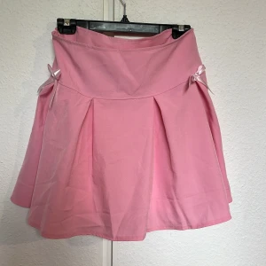 Rosa kjol - Måste tyvärr sälja min fina kjol då jag beställde fel storlek.  Kjolen är i storlek M. Den är helt  oanvänd. Kjolen har två lager, en underkjol i ljusrosa med spetskant.