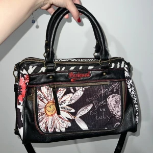 En väska - En väska från Desigual. Den är använd men i fint skick✨rymmer ganska mycket så man kan få plats med många grejer🤍 hör av er om ni vill ha flera bilder✨ köparen står för frakten!