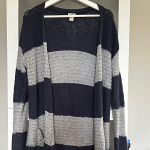 Stickad kofta  - En stickad kofta med marinblå och gråa ränder. Fickor på sidorna Storlek M Liten i storlek så skulle nog mer säga att den passar en XS-S