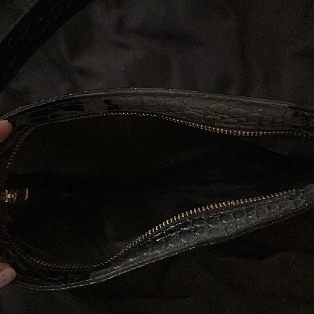 Säljer en jätte fin svart handväska med gulddetaljer, den är varsamt använd. . Väskor.