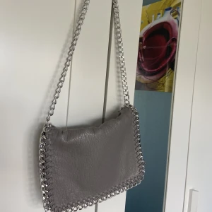 Tiamo väska  - Säljer denna superfina ljus grå väskan från tiamo. Säljer då den inte kommer till användning längre då jag har andra liknande väskor. Väskan är i nyskick, men har en liten defekt kom privat för bild. Priset går att diskutera. 💘💘