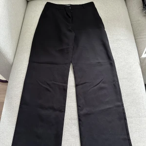 Svarta kostymbyxor  - Högmidjade kostymbyxor från madlady. De är wide leg och är långa. Bra skick!