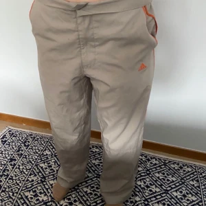 Byxor  - Baggy adidas byxor. Lite gråaktiga, med orangea streck längst sidorna. Strl M men långa. Man kan vika ner kanterna så de blir low waist, super snygga.💕