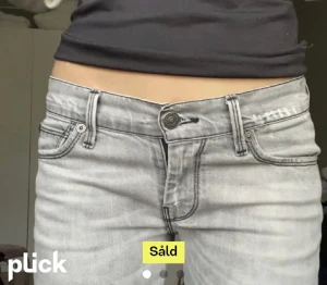 Gråa lågmidjade jeans - Jättefina gråa lågmidjade jeans med slits där nere.🤍 Storlek 38 men skulle säga att det är mer 34-36. (Lånade bilder)