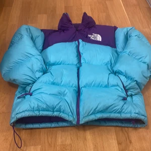 The North Face dunjacka lila/turkos  - Kan skicka fler bilder i bättre ljus. Använd en vinter, väldigt bra skick. Storlek L passar M. Justerbar runt midjan. Pris kan diskuteras. Nypris 3000