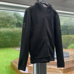 Svart Sail Racing hoodie  - Tja, säljer nu min hoodie som jag växt ur. Den är i väldigt bra skick skulle säga 8,5/10. Hör av er vid minsta fråga och pris kan absolut diskuteras.
