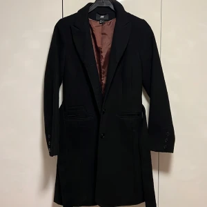 Svart kappa  - Svart kappa med skärp samt fickor 