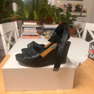 Svarta läder Kilcklcksor  - Bra skicken ganska använda, enskatacka skrapor svarta kilcklackar, ca 8 cm klack 