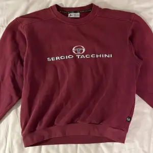 Röd sweatshirt från Sergio Tacchini. Passar bra på mig som ofta bär S/M. Säljer p.g.a att den inte använts ofta. Mycket bra skick.