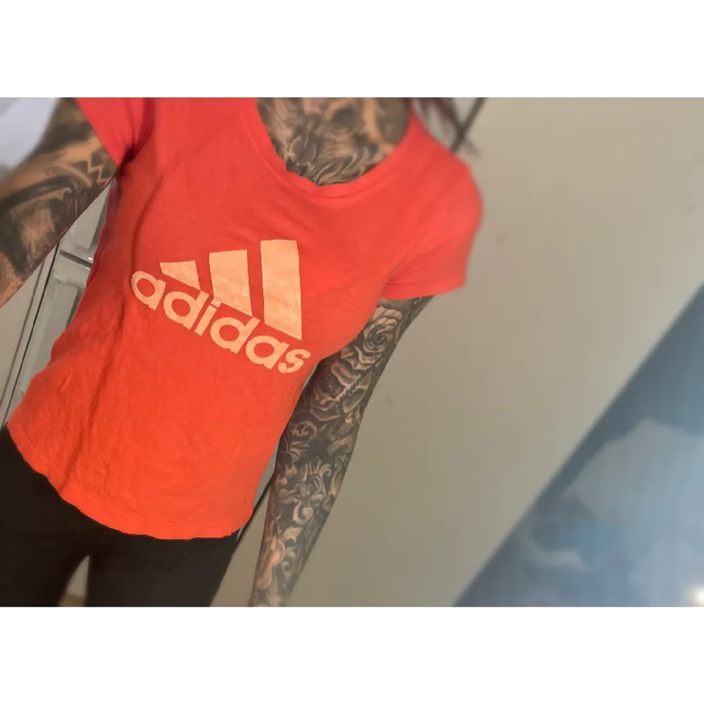 Adidas T-shirt, färgen är röd/rosa/korall. Litet hål nedtill. Storlek 152, passar XS. T-shirts.