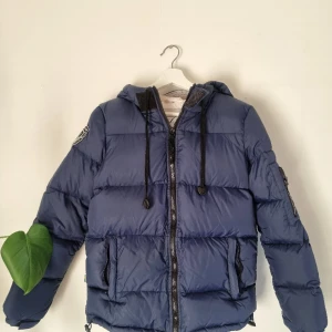 Vinterjacka D. Brand - En varm vinterjacka från D. Brand. Använd men väldigt fint skick! Det enda jag kan anmärka är att snörerna ser kanske något slitna ut och det är lite lite missfärgat vid kragen. Nypris 1999kr.