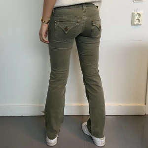 Gröna lågmidjade jeans  - Så coola gröna lågmidjade jeans ifrån guess! Midjemåttet är 74cm och innerbenslängden 76cm, hon på bilden är 165 för referens💕