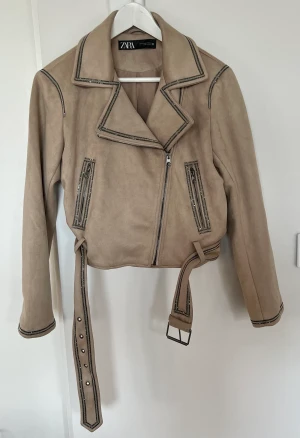 ZARA biker/mockajacka OANVÄND - Oanvänd jacka från Zara. Storlek M.  Färg: beige med pärldetaljer.  I nyskick.