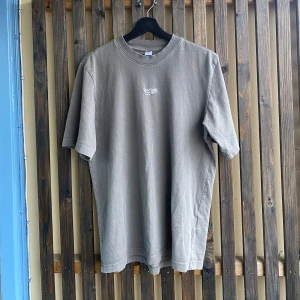 Reebok T-shirt - Ljusbrun/grå T-shirt från Reebok med perfekt krage i storlek M. Pris: 89kr