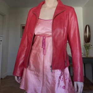 Röd skinnjacka - Äkta skinn. Storlek M. Märke Mango, Vintage. Inga defekter. Färgen är röd/vinröd.