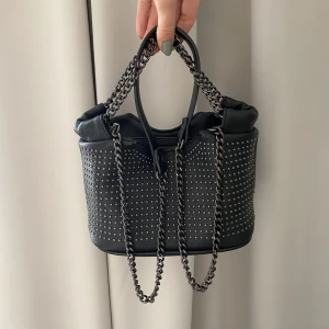 Väska med mini nitar - Svart väska med mini ”nitar”. Har på-och-avtagbar axelrem! Storlek: ca 20x15x10 Väskan är i superfint skick! Har du några frågor så är det var stat skriva!💘