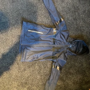 Regn/vind jacka - Nu säljer jag min helly Hansen regnjacka. Köpt för 1100kr. Den har inga skador eller slitningar förutom att det är ett överstruket namn på insidan av jackan, se på bild 3