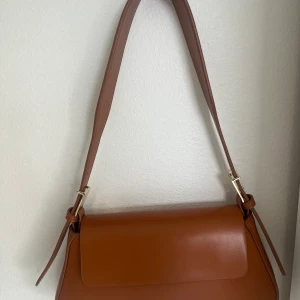 väska från zara! - en fin väska i en rostig färg! aldrig använd men superfin till både vardags och fest!