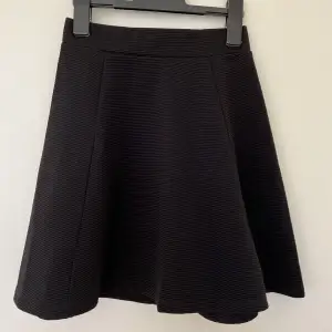 En svart kjol från H&M med en dragkedja där bak.