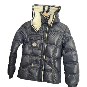 Moncler jacka - Säljer min andra moncler jacka (äkta) köpt på Vestiaire pga för liten. Den är mörkblå. Inga defekter, skriv för bilder på.