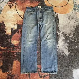 vintage Levis Jeans i moddelen 501. Byxorna är i bra skick förutom några repor på framsidan och lite slitage nere vid fotöppningen.  Storleken är 34  Dm mer frågor 🤞🍻