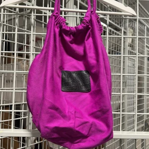 Väska  - Rosa/ lila väska i fint skick. Litet ytterfack med dragkedja på sidan. Säljs för 50kr 