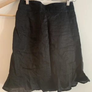 Kjol - Åtsittande med volang nedtil, har dragkedja. Från tidigt 2000-tal 