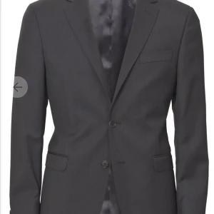 Oscar Jacobson kostym - Kavaj, Modell Fuego, Två-knäpp 100% ull från väveriet Lanificio T.G di Fabio. Strl 46. Svart  (colour311). Byxa,Modell Desmond 100% ull fr samma väveri. Strl 48. Svart (311). Byxor upplagda av skräddare – innerlängd 74 cm.  Nypris 5,500 kr. Säljes 2,000kr