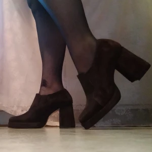 Mockaskor fyrkantig tå  - Världens coolaste 70-talsklackar! De är i mocka i använt men fint skick, med trendig fyrkantig tå och blockklack. Vet inte storlek men jag har 35 och de är lite trånga på mig så skrev 34-35 som storlek.