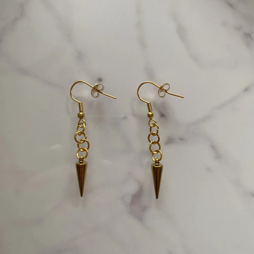 (Säljer för mitt UF) Studded Earrings Gold Long är ett par guldiga örhängen (den långa varianten) gjorda av rostfritt stål. Perfekta för att göra din outfit 10/10. Vårt pris för dessa är endast 30 kr ?!. Accessoarer.