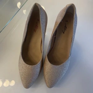 Klackar  - Beige/champagne glittriga klackar från Skopunkten. Låg & bekväm klack, endast använda en gång 