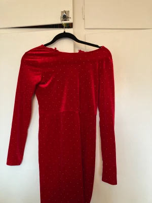 Röd klänning  - En röd klänning med guld pärlor på. Jag har använt den 3 gånger och är perfekt för någon fest eller jul mm. Klänning är i storlek 146-152