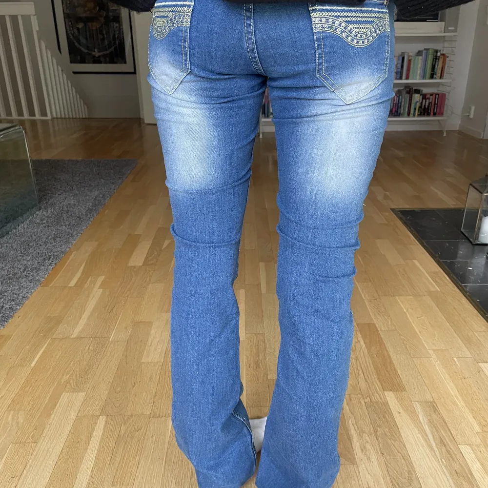 Säljer dessa lågmidjade bootcutjeans med coola detaljer på benet!. Jeans & Byxor.