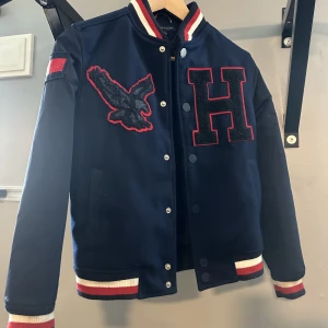Tommy Hilfiger jacka  - Fodrad baseball jacka från Tommy Hilfiger i mycket fint skick.  Storlek 8-10 år (ca 140-150)