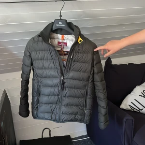 Parajumper vindjacka - Här är en parajumper vindjacka som är i väldigt bra skick det finns inga skador på den och den har kvar pris lapp. Modellen är 162 cm lång och den sitter bra   Ny pris: 3699kr Mitt pris: 1699kr