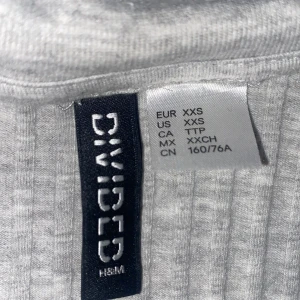 Klänning - Grå klänning köpt på H&M. Storlek Xxs menär stretchig och V-ringad!💗