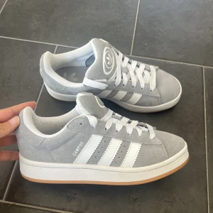 Adidas campus 00s - KÖP DIREKT FÖR 1500!                                         Snyggaste grå adidas campus 00s. Endast använda fåtal gånger så de är bra skick! Storlek 38, men stora i storleken så passar 39. Kör budgivning med start på 1000kr