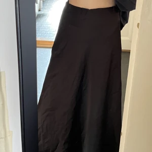Satinkjol - Silkig svart långkjol, använd typ 1-2 gånger.🖤 Slutar nån decimeter ovanför fötterna/anklarna på mig som är ca 170cm.  