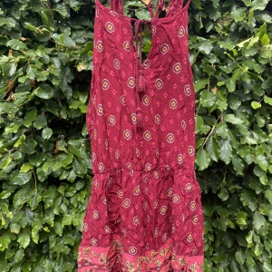 Somrig byxdress - Vinröd byxdress med med rosa/gula detaljer. Super fin till sommaren, passar både till vardags och till fest