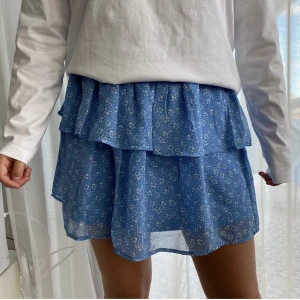 Blå Volangkjol - Säljer denna snygga volangkjol från Pieces. Storlek L men skulle säga att den passar S - L (stretch i midjan). Perfekt nu till sommaren! Har bara legat i min garderob, köpte för 2 år sen men har bara använts 1-2 gånger. Har av er vid intresse/ev. frågor💙🩵